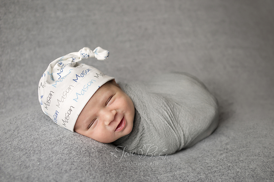 smiling baby boy in name hat