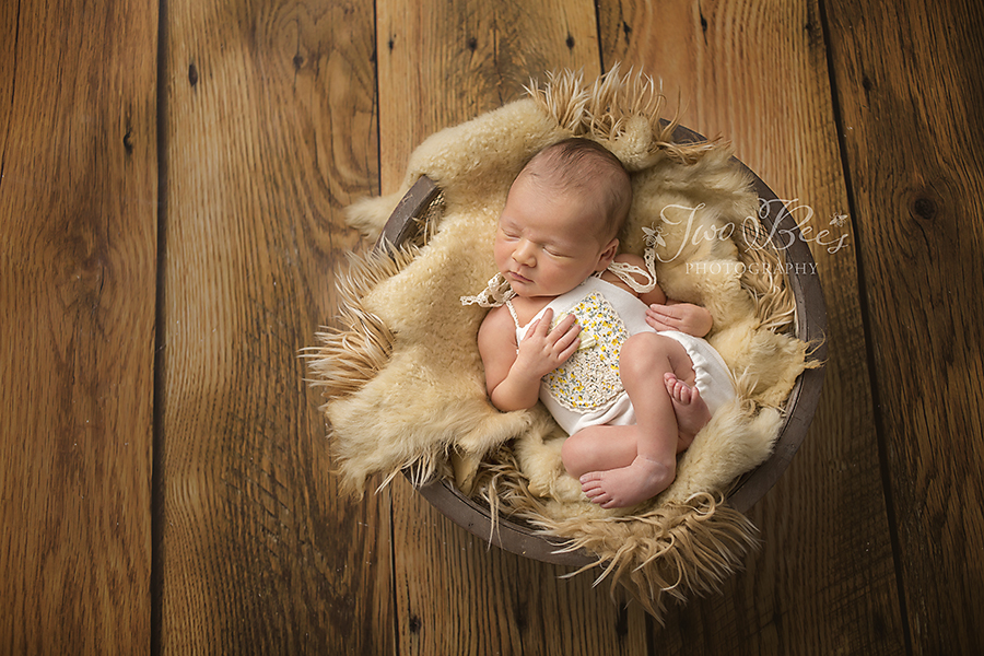 newborn girl on fur in basket